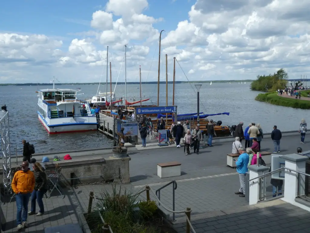 Bootssteg mit Menschen und Schiffen